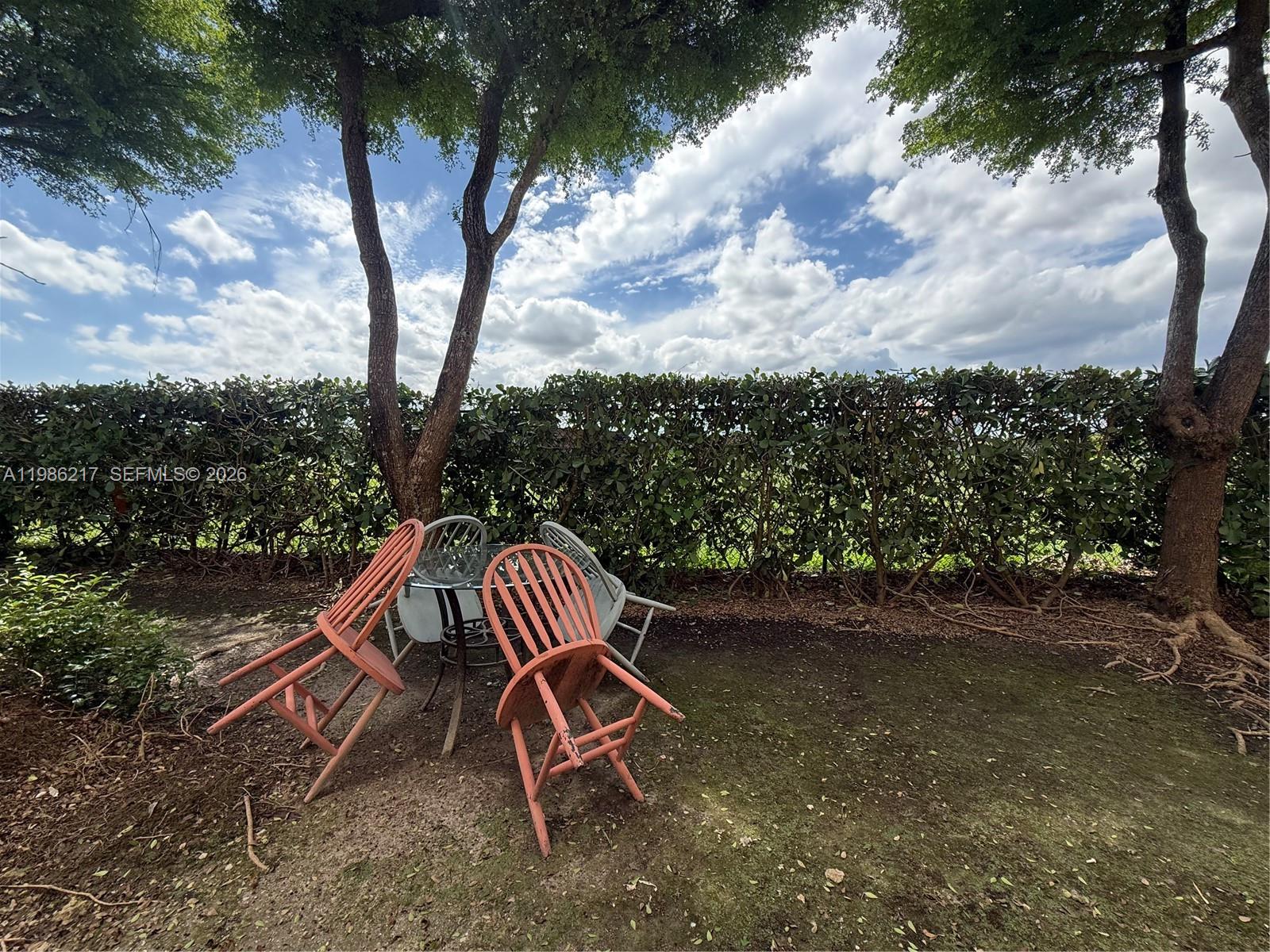 940 Northeast 33rd Terrace, Unit 101 Homestead, FL 33033 - Photo 17 of 20 a view of a wooden deck with a bench and wooden fence