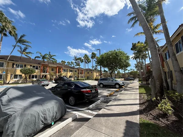 a city street lined with lots of traffic and trees