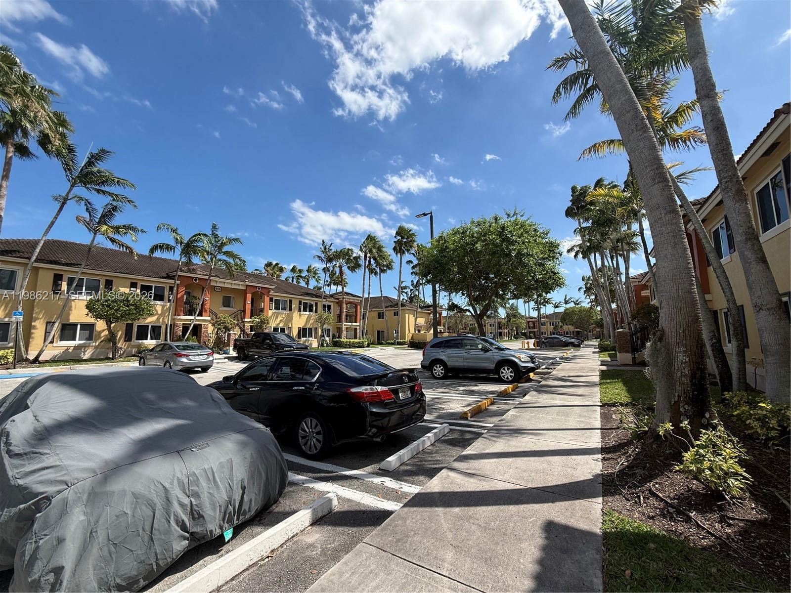 940 Northeast 33rd Terrace, Unit 101 Homestead, FL 33033 - Photo 3 of 20 a city street lined with lots of traffic and trees