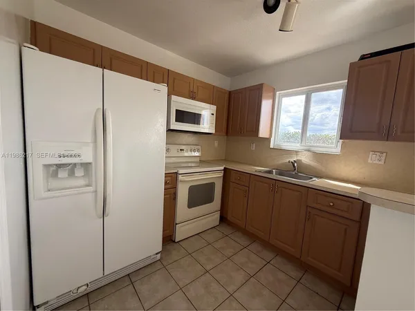 a kitchen with white cabinets and white appliances