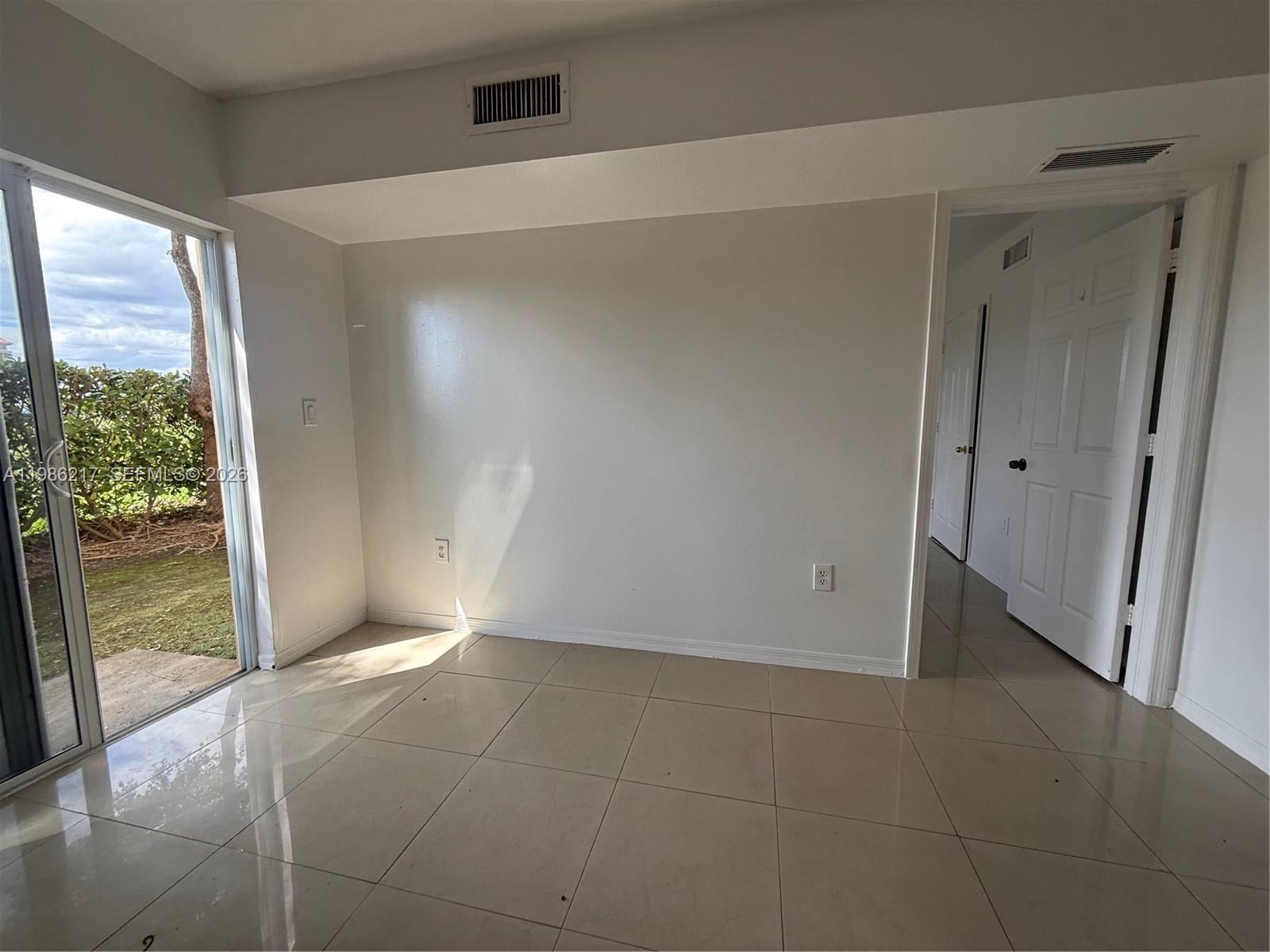 940 Northeast 33rd Terrace, Unit 101 Homestead, FL 33033 - Photo 9 of 20 a view of an empty room and window