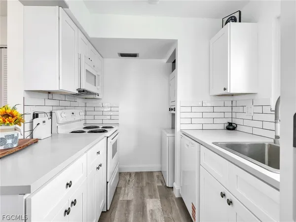 a kitchen with granite countertop a sink stove and cabinets