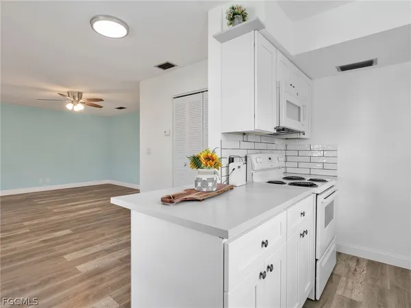 a kitchen with a sink cabinets and wooden floor
