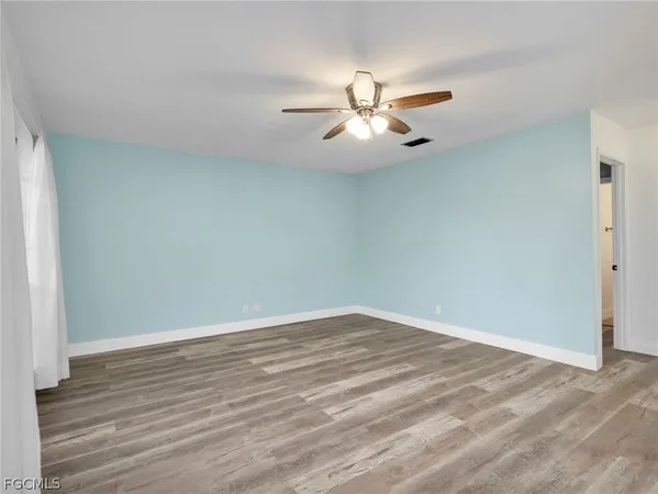 a view of empty room with wooden floor