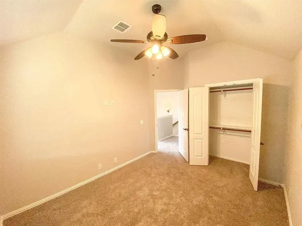 a view of a room with a empty space and a ceiling fan