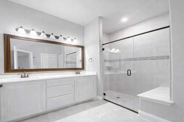 a bathroom with a double vanity sink and mirror