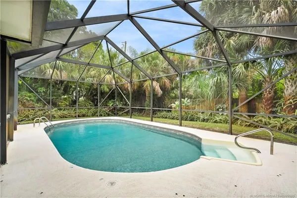 a view of a swimming pool with a yard and sitting area