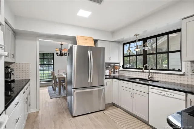 a kitchen with granite countertop white cabinets and white appliances