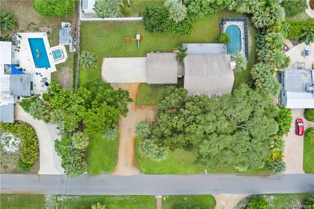 an aerial view of residential houses with outdoor space and trees all around