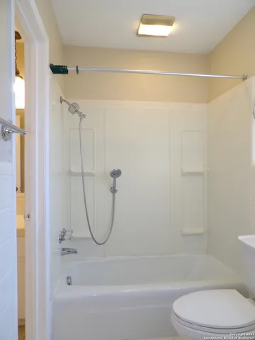 a bathroom with a toilet and a shower