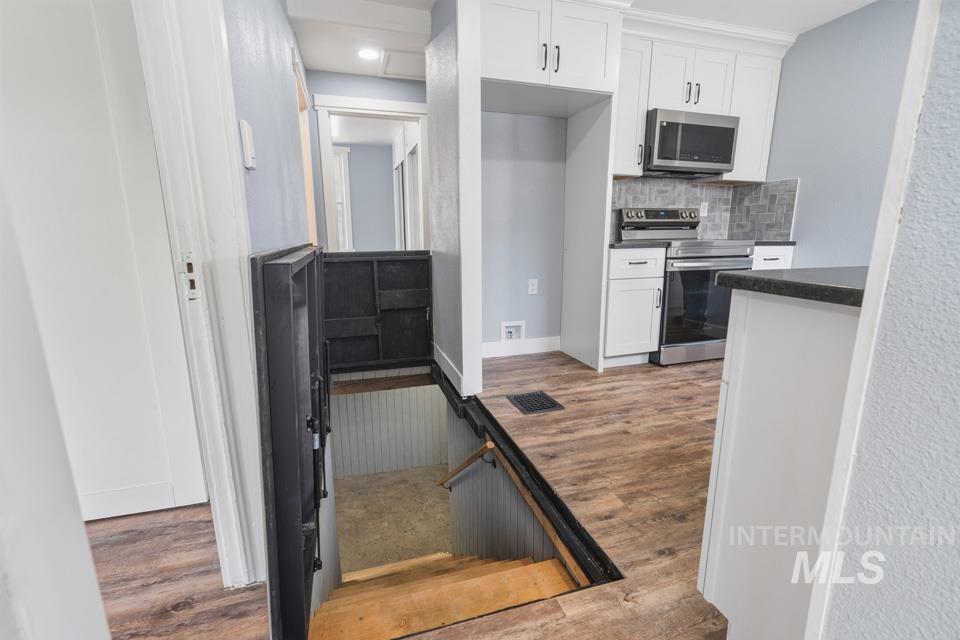 253 West Court Street Weiser, ID 83672 - Photo 13 of 35 Kitchen featuring light wood finished floors, stainless steel appliances, white cabinetry, tasteful backsplash, and recessed lighting