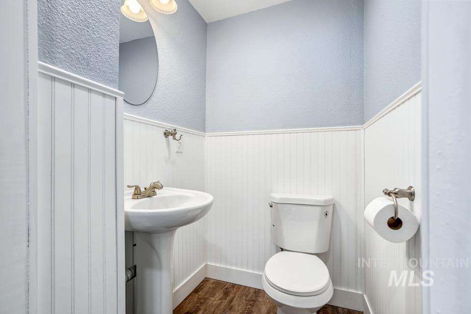 253 West Court Street Weiser, ID 83672 - Photo 27 of 35 Bathroom with wainscoting, a textured wall, and dark wood-type flooring