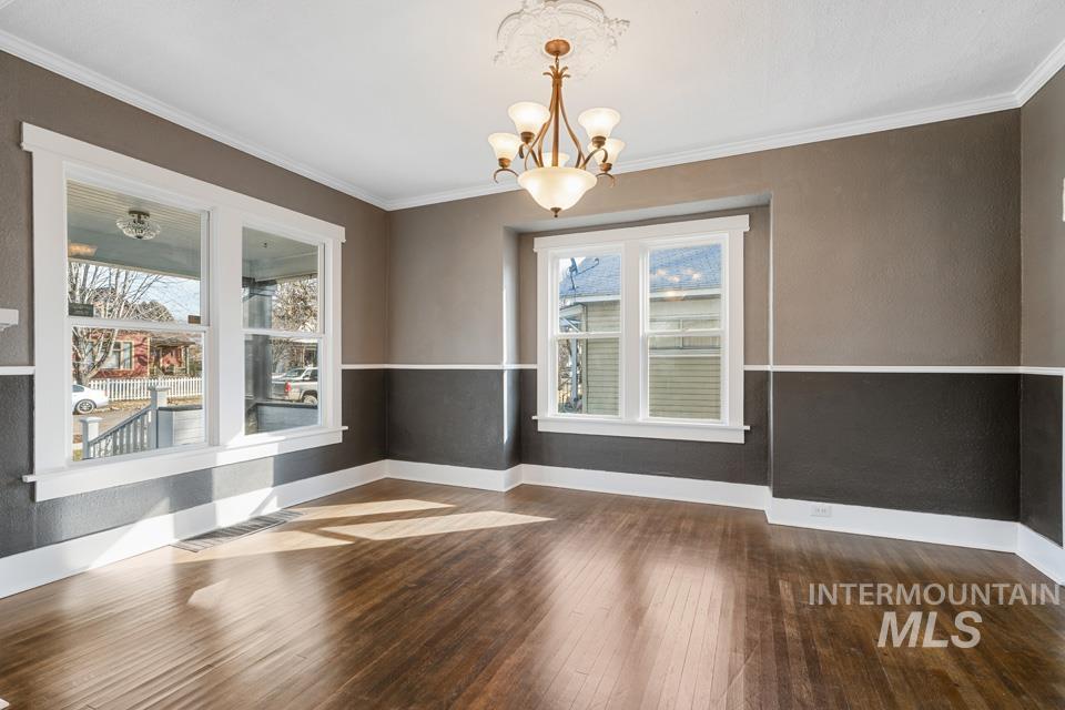 253 West Court Street Weiser, ID 83672 - Photo 6 of 35 Unfurnished dining area featuring dark wood-style flooring, suspended lighting, and crown molding