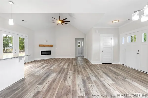 a view of empty room with wooden floor and fan