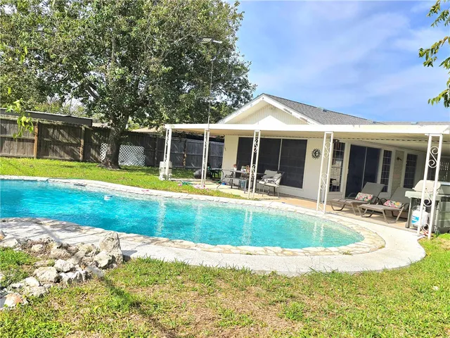 a view of a house with swimming pool and a yard