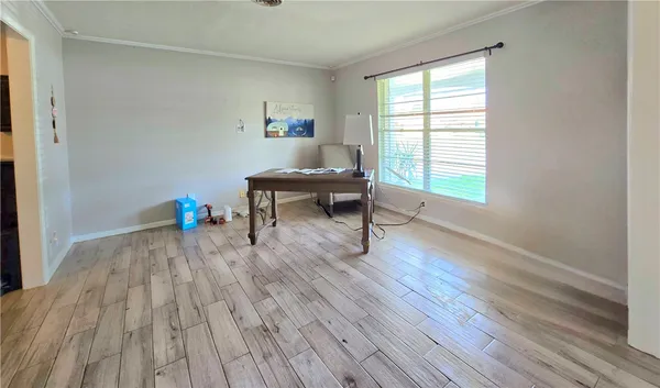 a living room with wooden floor and a table