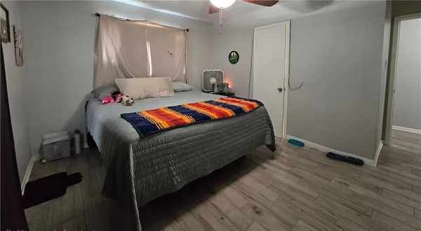 a bedroom with a bed and wooden floor