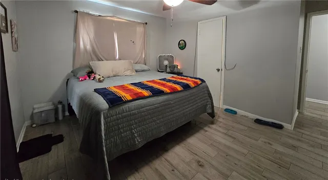 a bedroom with a bed and wooden floor