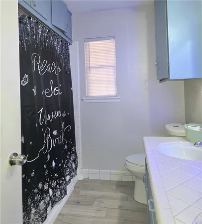 a bathroom with a toilet and a shower curtain