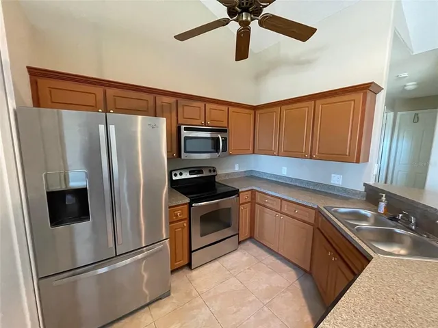 a kitchen with stainless steel appliances a refrigerator sink and microwave