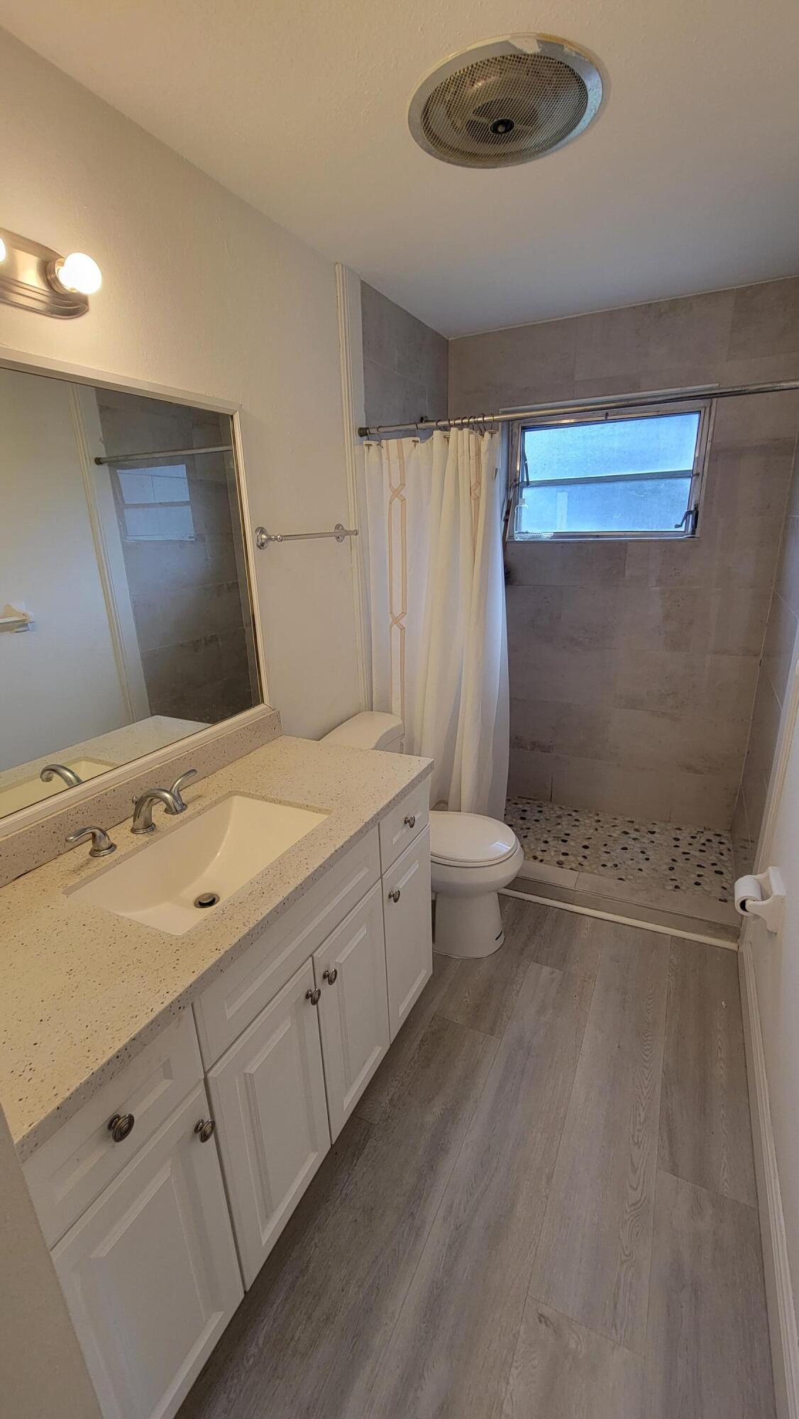 3340 Jog Road Greenacres, FL 33467 - Photo 13 of 20 a bathroom with a double vanity sink toilet mirror and shower