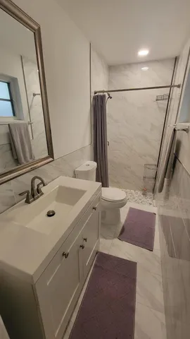 a bathroom with a sink a toilet and a mirror