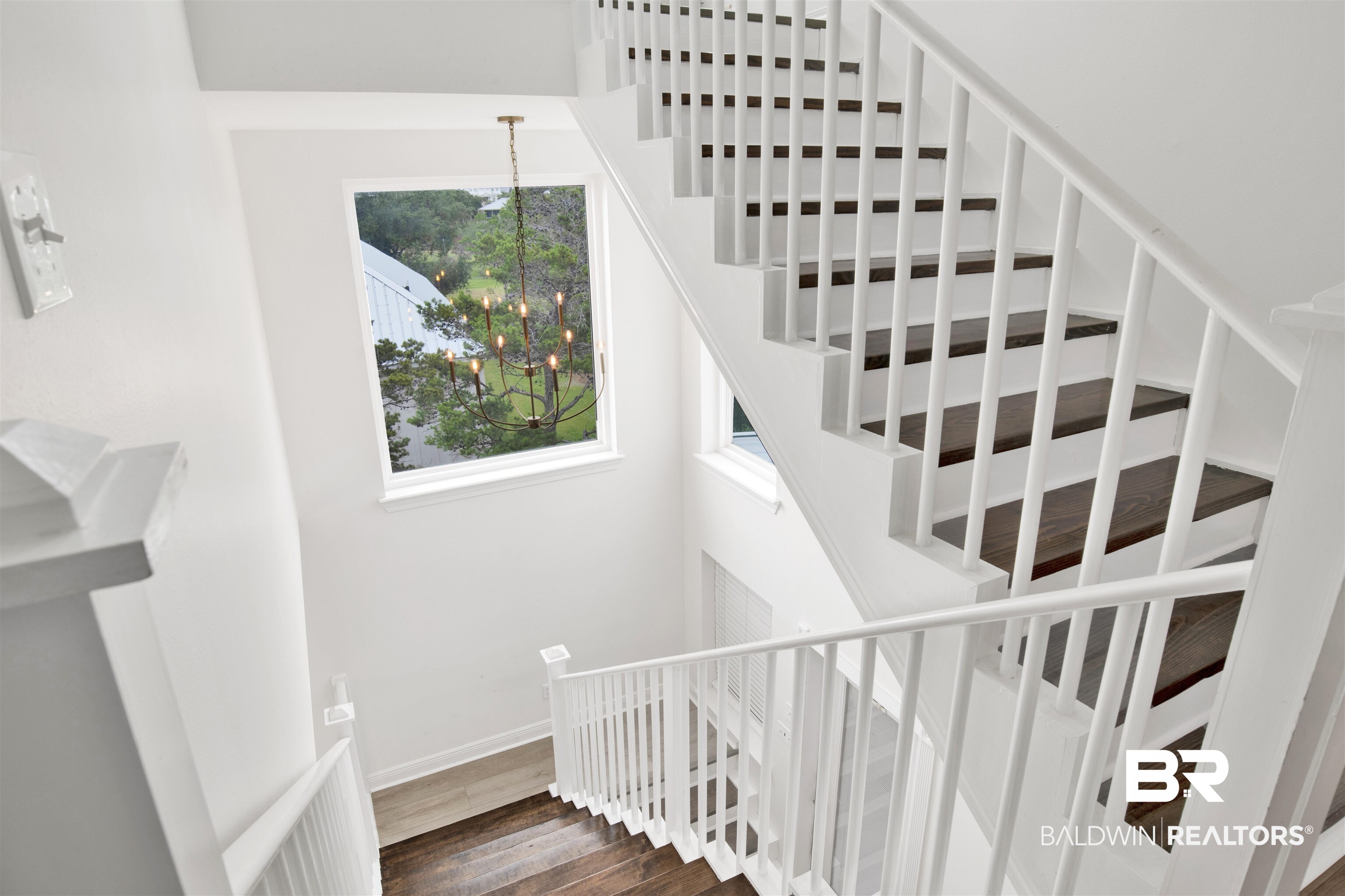 30351 River Road Orange Beach, AL 36561 - Photo 27 of 44 Stairwell featuring wood-finish treads, white painted risers, and white balusters