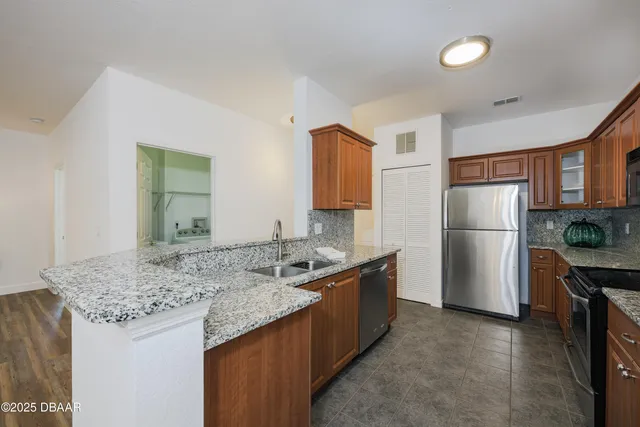 a kitchen with stainless steel appliances granite countertop a sink stove and refrigerator
