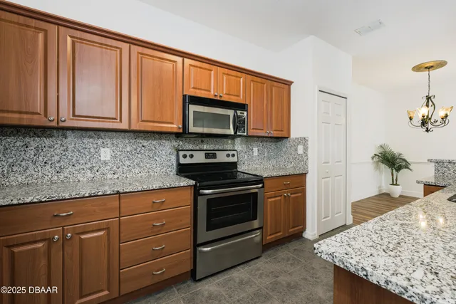 a kitchen with granite countertop a sink cabinets and stainless steel appliances