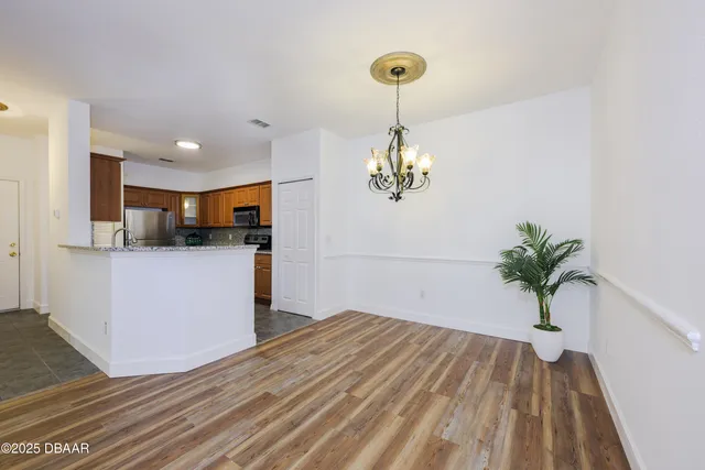 a view of a room with wooden floor and kitchen view