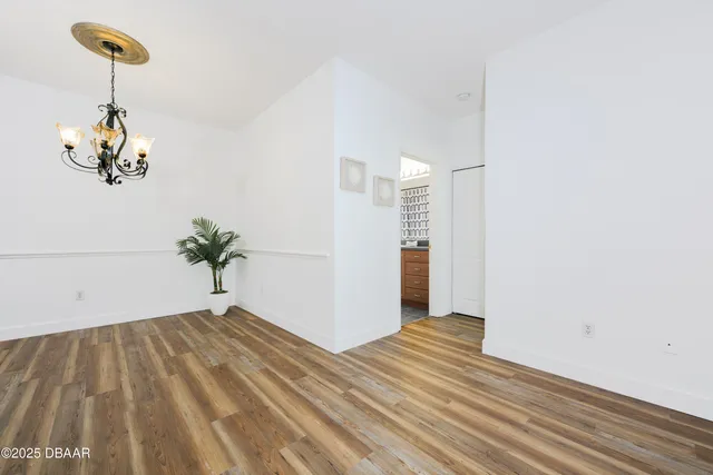 a view of a room with wooden floor and a ceiling fan