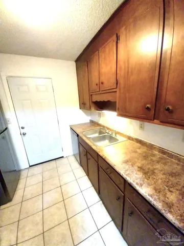 a view of kitchen with granite countertop cabinets and sink