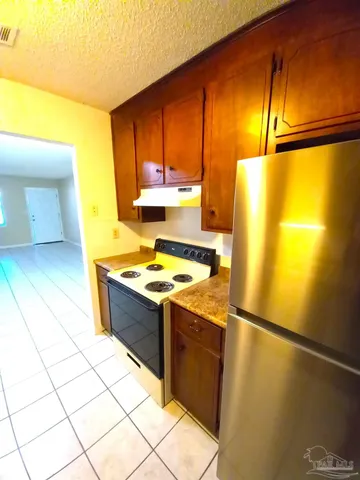 a kitchen with stainless steel appliances granite countertop a refrigerator and a stove