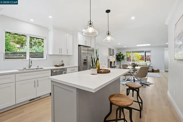 a kitchen with a dining table chairs sink and cabinets