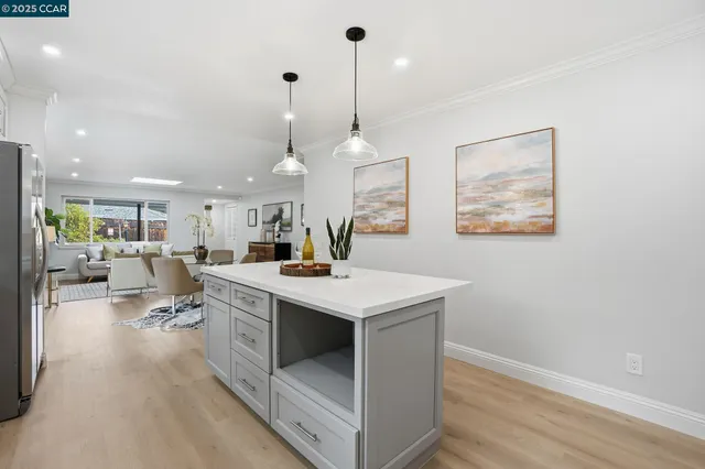 a view of a kitchen counter top space with furniture and wooden floor