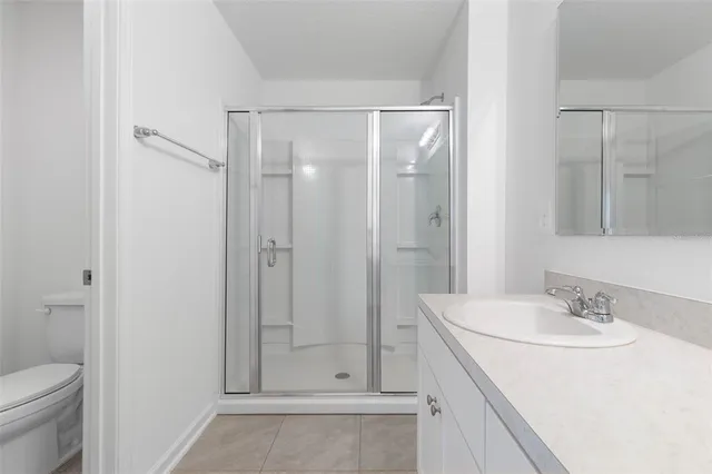 a bathroom with a shower sink vanity and toilet
