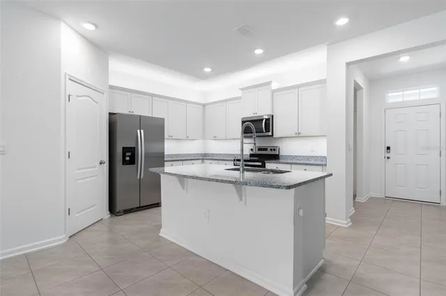 a kitchen with stainless steel appliances granite countertop a refrigerator stove and sink