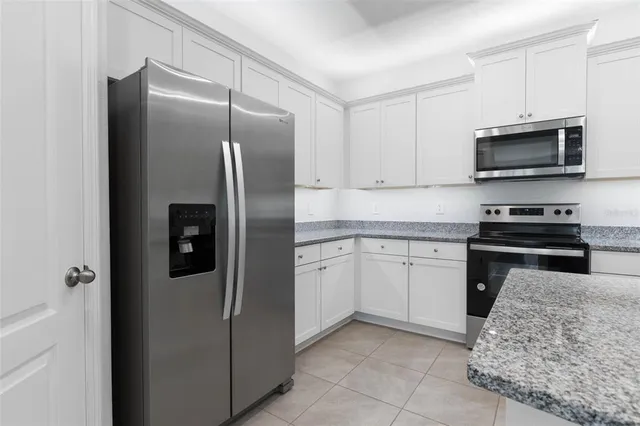 a kitchen with stainless steel appliances granite countertop a refrigerator and a stove top oven