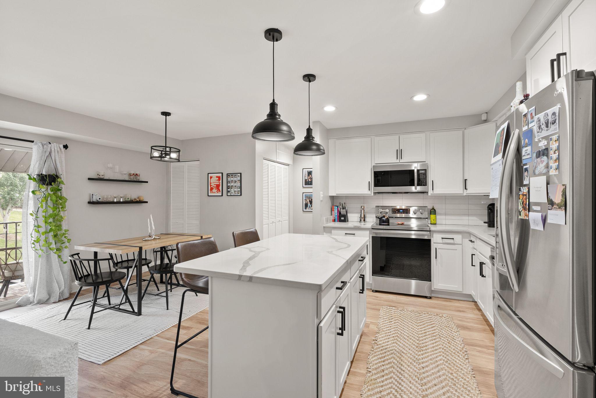 6137 Edsall Road, Unit L Alexandria, VA 22304 - Photo 12 of 36 a kitchen with stainless steel appliances kitchen island granite countertop a refrigerator a stove top oven a sink dishwasher and white appliances