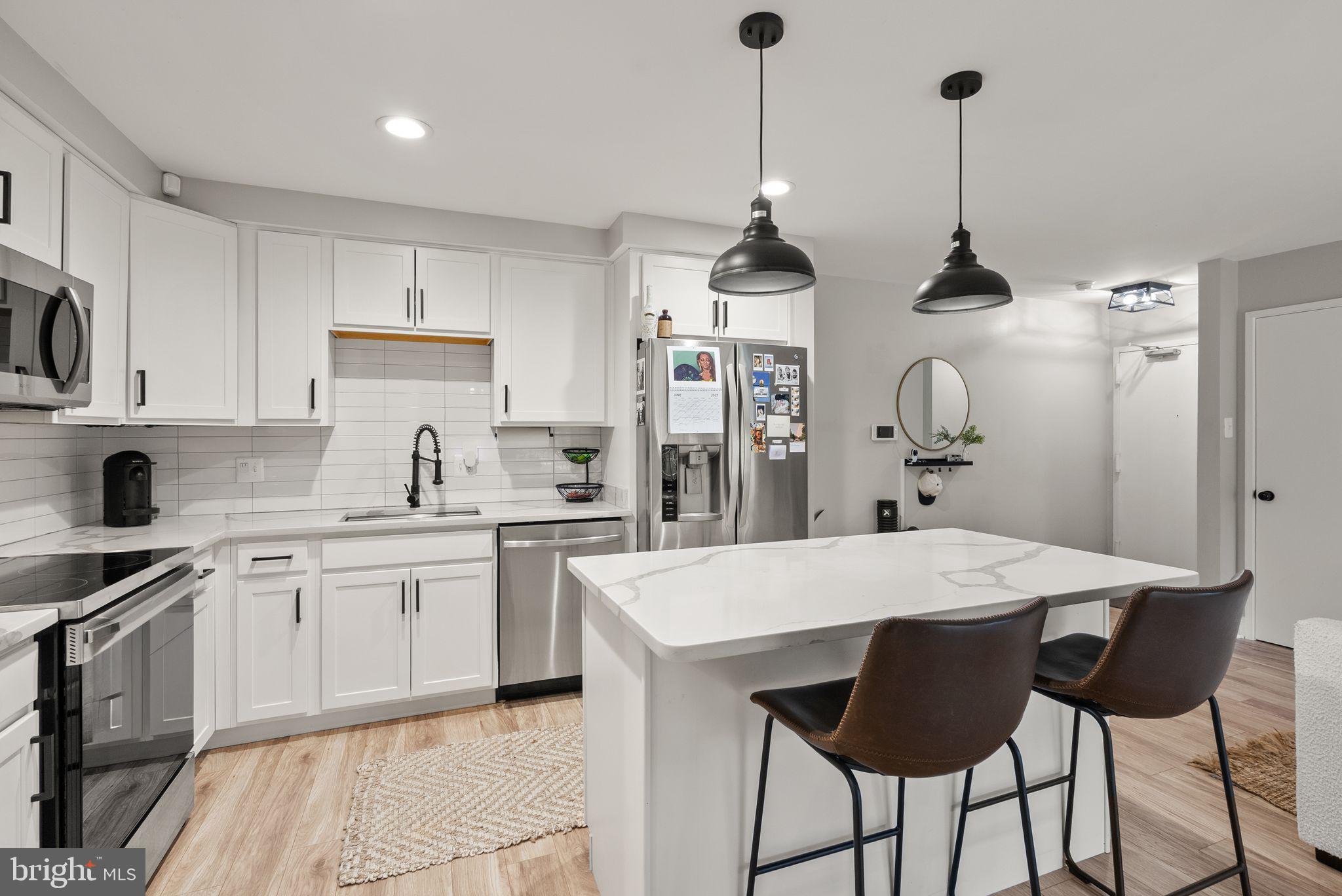 6137 Edsall Road, Unit L Alexandria, VA 22304 - Photo 14 of 36 a kitchen with stainless steel appliances kitchen island granite countertop a sink a stove a refrigerator and cabinets