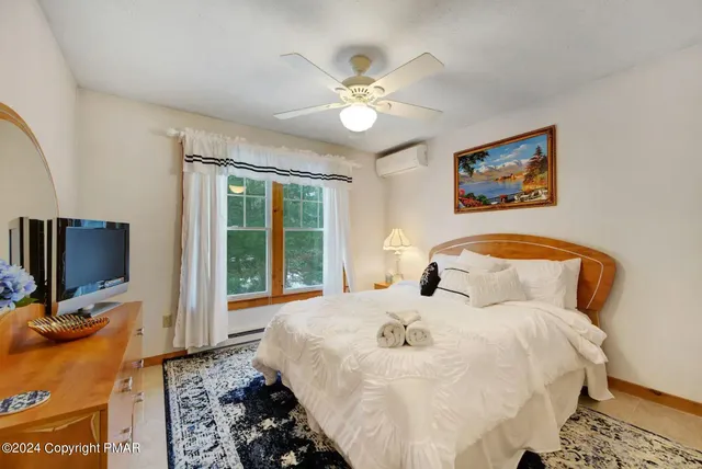a spacious bedroom with a bed and a flat screen tv