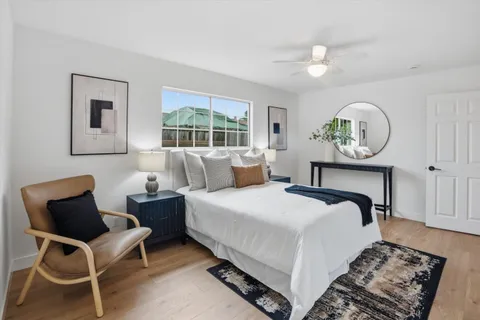 a bedroom with a bed and a painting on the wall