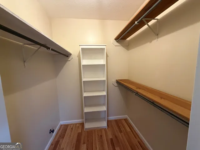 a view of walk in closet with empty racks