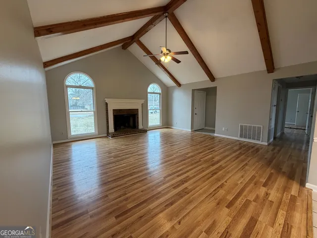a view of a livingroom with wooden floor and a fireplace