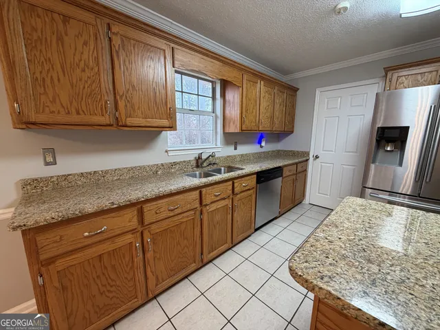 a kitchen with stainless steel appliances granite countertop wooden cabinets a sink and dishwasher