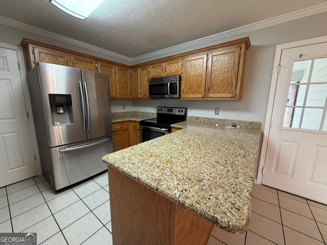 a kitchen with stainless steel appliances granite countertop a refrigerator sink and microwave