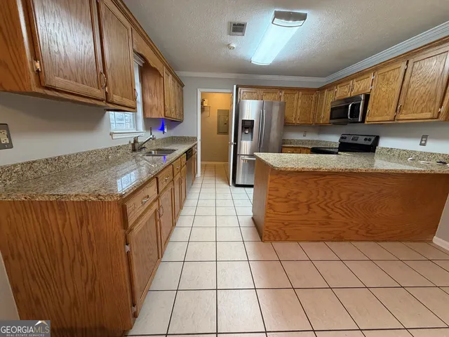 a kitchen with stainless steel appliances granite countertop a stove a sink dishwasher and a refrigerator