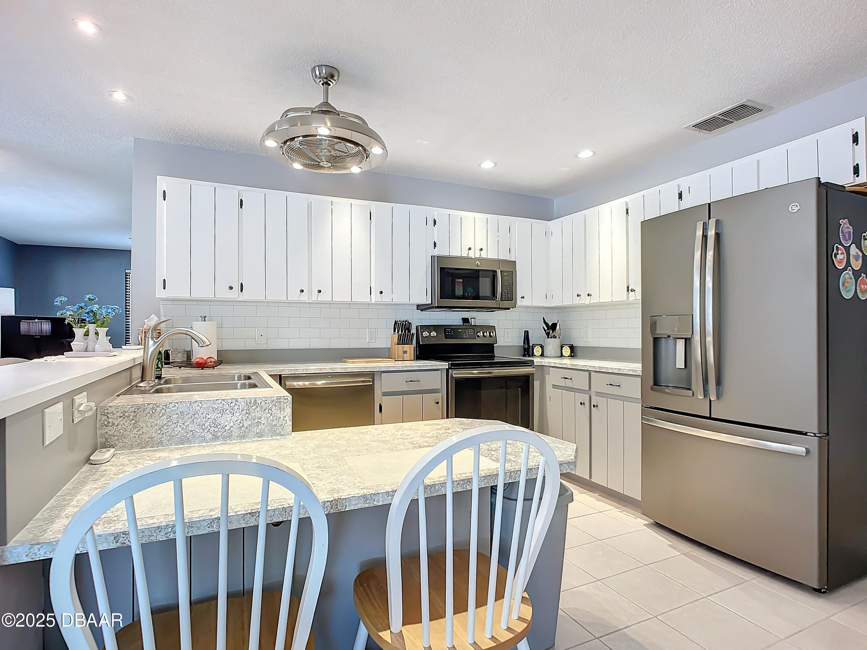 39 Crooked Pine Road Port Orange, FL 32128 - Photo 18 of 47 a kitchen with granite countertop a refrigerator a stove a sink cabinets and a dining table