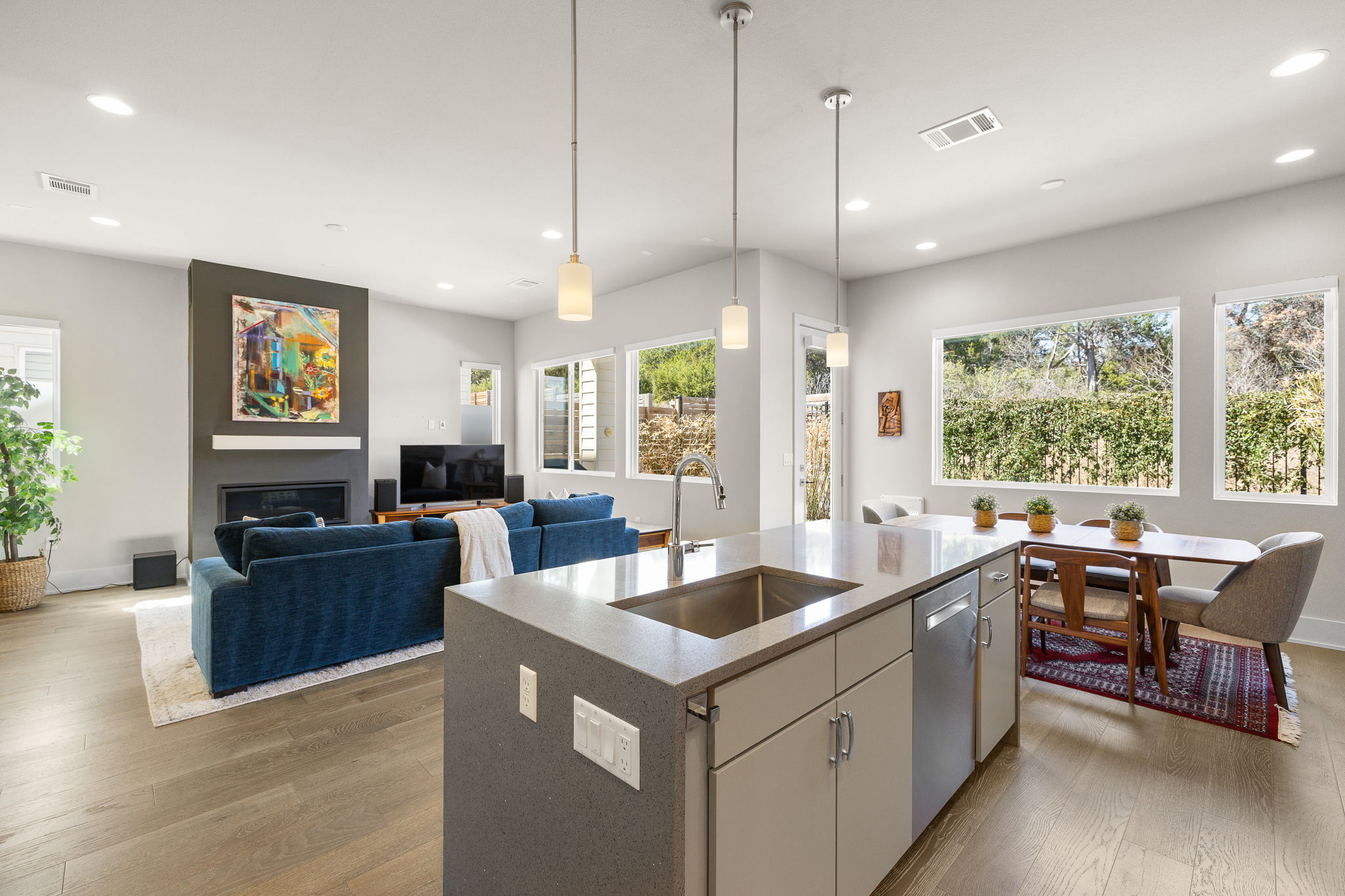 5214 Pink Poppy Pass Austin, TX 78735 - Photo 34 of 34 Kitchen featuring an island with sink, dark wood finished floors, open floor plan, light stone countertops, and pendant lighting