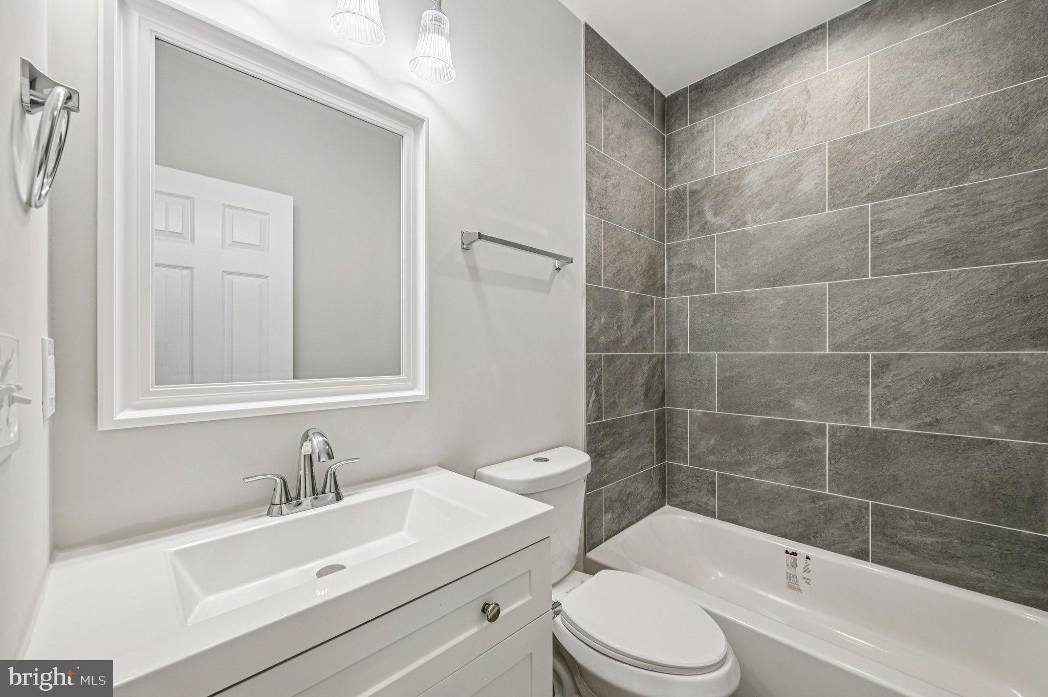 750 Reservoir Street, Unit A Baltimore, MD 21217 - Photo 16 of 23 a bathroom with a sink a toilet and shower